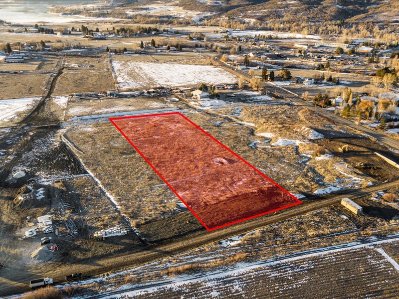 Aerial view of property and surrounding area with property parcel outlined and rural landscape