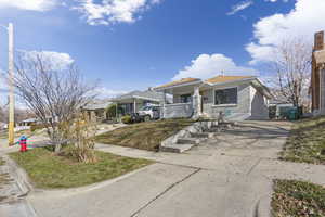 Bungalow-style home featuring brick siding, driveway, and a front yard