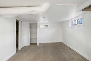 Below grade area with carpet flooring and a textured ceiling