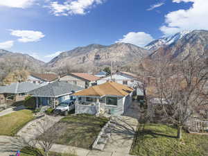 View of front facade with a mountain view, concrete driveway, and a front yard