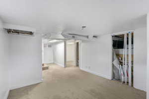Finished below grade area with carpet floors, a textured ceiling, and stairs