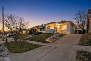 Bungalow-style house with brick siding, concrete driveway, and a front yard