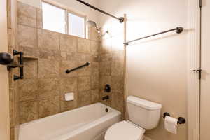 Full bathroom featuring toilet and shower / washtub combination