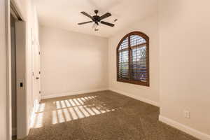 Unfurnished room with a ceiling fan and carpet
