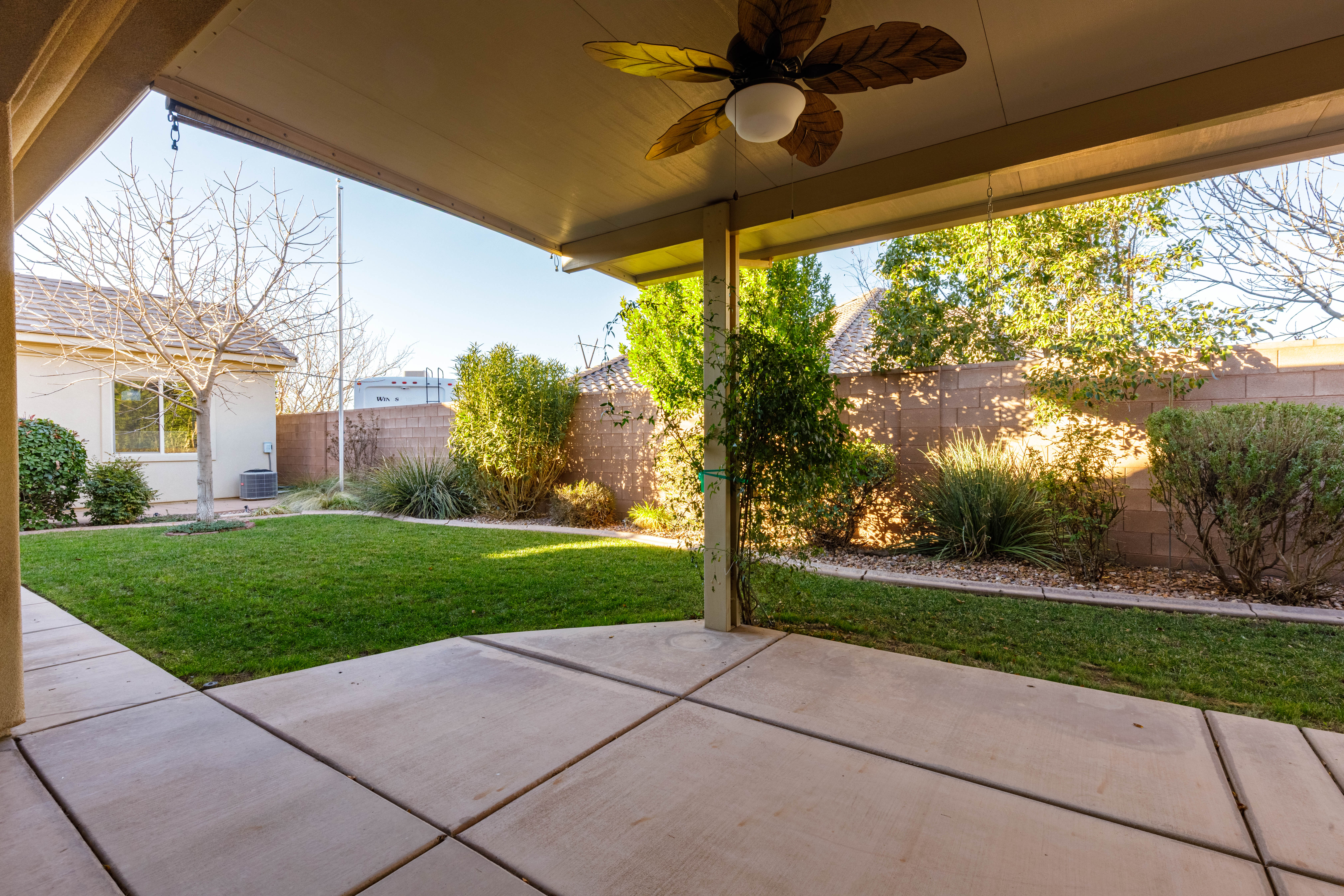 Fenced backyard featuring a patio and ceiling fan