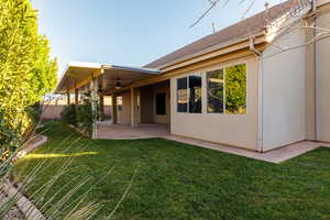 Back of property with a patio, stucco siding, ceiling fan, and a shingled roof