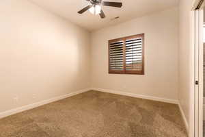 Spare room featuring carpet and ceiling fan