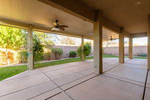 Fenced backyard with a ceiling fan and a patio area