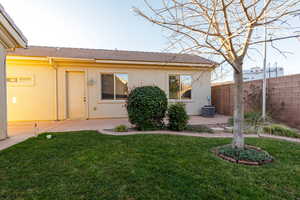 Rear view of house featuring stucco siding and a tiled roof