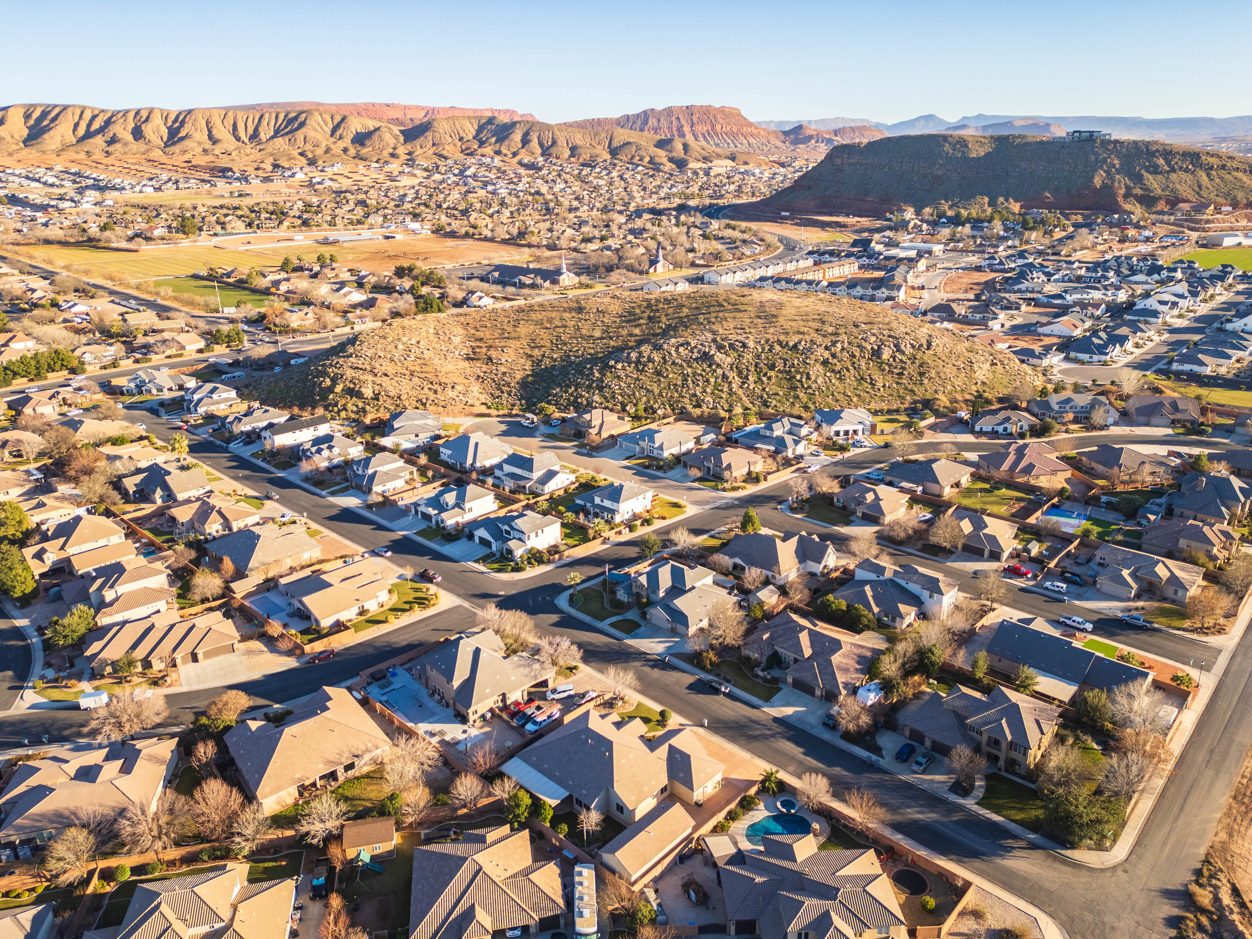 Aerial overview of property's location featuring a mountainous background and nearby suburban area