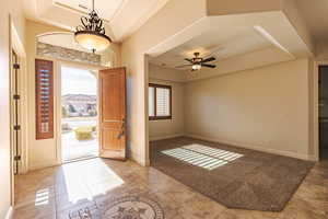 Entrance foyer featuring a raised ceiling and a ceiling fan