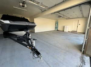 Garage featuring freestanding refrigerator and a garage door opener