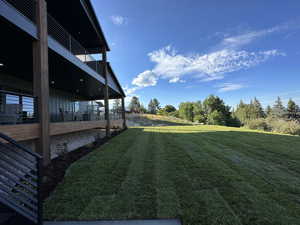 View of green lawn with a patio