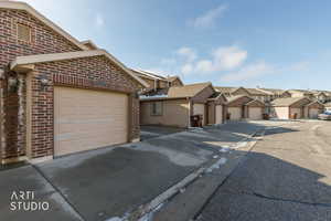 View of front facade with brick siding, a residential view, and driveway