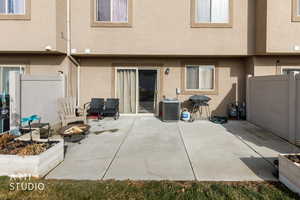 Back of house featuring an outdoor fire pit, stucco siding, and a patio