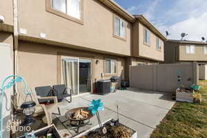 Back of house featuring an outdoor fire pit, stucco siding, and a patio area