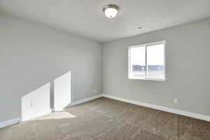 Empty room with baseboards and light carpet