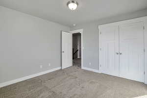 Unfurnished bedroom with carpet flooring and a closet
