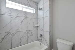 Bathroom featuring toilet and shower / washtub combination