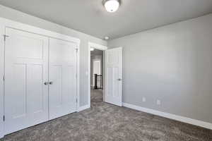 Unfurnished bedroom featuring carpet flooring and a closet