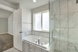 Full bath featuring a bath, a shower stall, recessed lighting, and light colored carpet