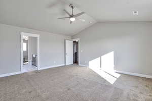 Unfurnished bedroom with lofted ceiling, light carpet, a ceiling fan, and ensuite bath