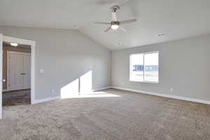 Spare room with light colored carpet, lofted ceiling, and a ceiling fan