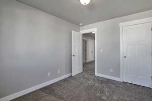 Unfurnished bedroom with baseboards and carpet floors