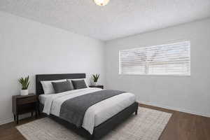 Bedroom with a textured ceiling and dark wood-type flooring