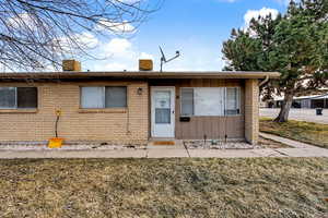 View of front of property with a front lawn, grass and brick siding