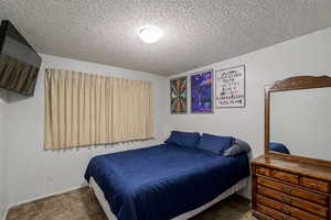 Bedroom with carpet flooring and a textured ceiling