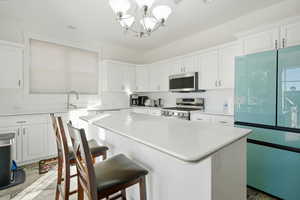 Kitchen featuring pendant lighting, white cabinets, and a kitchen island