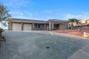 Ranch-style home with concrete driveway, a garage, and brick siding