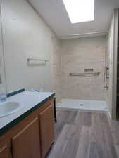 Full bath featuring a stall shower, light wood-style floors, and vanity