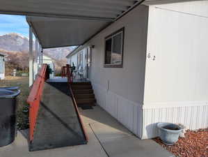 View of side of home with a mountain view and a porch