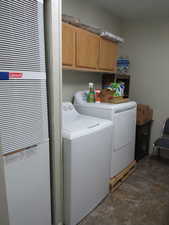 Laundry room with a heating unit, cabinet space, independent washer and dryer, and stone finish flooring