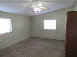 Carpeted empty room featuring a ceiling fan