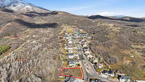 Aerial view of residential area with a mountainous background and property boundaries highlighted