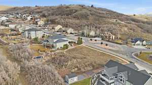 Aerial view of property and surrounding area featuring nearby suburban area and mountains