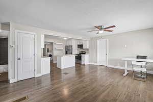 Unfurnished living room with light wood-style floors, washer / clothes dryer, a ceiling fan, and a textured ceiling