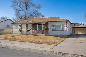 Bungalow-style home featuring a porch, a shingled roof, concrete driveway, and a carport