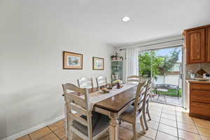 Dining space with baseboards and light tile patterned floors