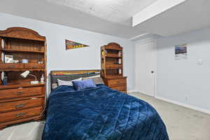 Bedroom featuring light carpet and a textured ceiling