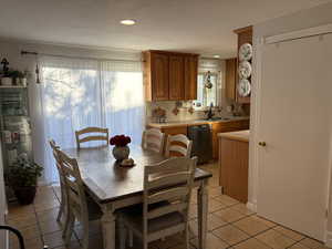 Dining space featuring light tile patterned floors, recessed lighting, and a textured ceiling