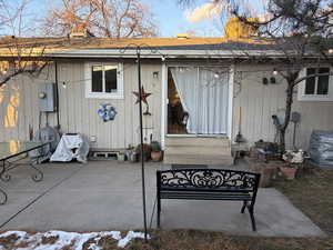 Back of property featuring a patio, entry steps, and roof with shingles