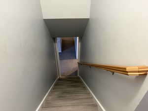 Stairway featuring baseboards and wood finished floors