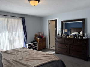 Carpeted bedroom featuring a textured ceiling