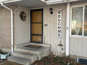 View of exterior entry featuring brick siding