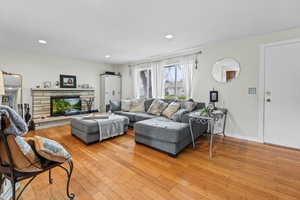 Living area featuring light wood-type flooring, recessed lighting, and a fireplace
