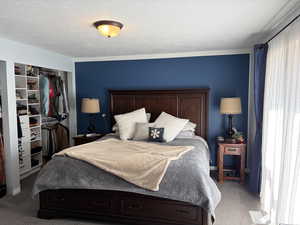 Bedroom featuring a closet, carpet, and a textured ceiling